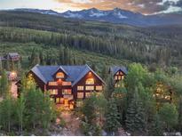 Stunning exterior view of a mountain home surrounded by lush trees and a breathtaking mountain backdrop at 300 Gold Hill Rd, Breckenridge, CO 80424