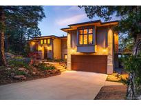 Beautiful home with a lush landscape, large driveway, and garage entrance on a sunny day at 8932 Eastridge Rd, Golden, CO 80403