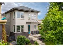 Modern two-story home featuring a turquoise front door, brick accents, and a well-manicured front yard at 1813 W 67Th Ave, Denver, CO 80221