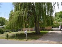 Charming brick home with a large willow tree, green lawn, and white mailbox at 2885 Quay St, Wheat Ridge, CO 80033