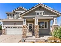 Two-story house with gray siding, stone accents, and a two-car garage at 17 Ellendale St, Castle Rock, CO 80104