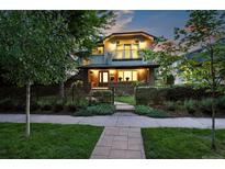 Charming two-story home featuring a brick facade, balcony, manicured lawn, and mature trees at 325 S High St, Denver, CO 80209