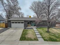 Charming home boasts a manicured lawn, a brick facade, and a two-car garage at 5946 Urban St, Arvada, CO 80004