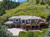 Expansive home with a three car garage and outdoor living space nestled in the hillside at 6405 Warriors Run, Littleton, CO 80125