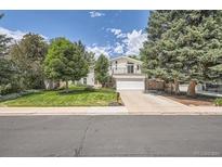 Charming two-story home featuring a manicured lawn, a balcony, and an attached two-car garage at 1011 S Holland Ct, Lakewood, CO 80226