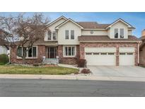 Charming two-story home features a brick facade, manicured lawn, and attached two car garage at 7965 S Eudora Cir, Centennial, CO 80122