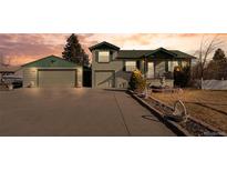 Charming home featuring attached two-car garage, manicured lawn, and attractive landscaping at 860 S Garrison St, Lakewood, CO 80226
