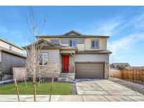 Charming two-story home features a red door, a well-manicured lawn and a two car garage at 15902 Stringhalt Way, Parker, CO 80134