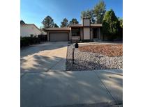 Ranch style home with a paved driveway and mature landscaping at 16786 E Kent Dr, Aurora, CO 80013