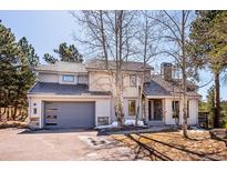 Charming home with stone accents, well-maintained landscaping, and a two-car garage offers curb appeal at 2122 Cramner Ct, Evergreen, CO 80439