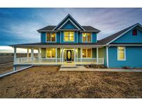 Charming two-story home with a covered porch and well-manicured landscaping at 52900 E 88Th Ave, Strasburg, CO 80136