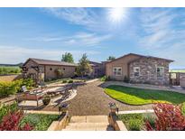 Stunning backyard with stone firepit, inviting seating area, and beautiful landscaping, perfect for outdoor gatherings at 11784 Spruce Mountain Rd, Larkspur, CO 80118