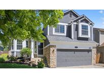 Charming two-story home with gray siding, stone accents, and a well-manicured front yard at 5323 E Hamilton Ave, Castle Rock, CO 80104