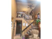 View of the carpeted staircase leading to the second floor, complemented by a wooden railing and earth tone walls at 14282 E Radcliff Cir, Aurora, CO 80015