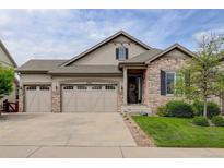 Inviting home featuring a three car garage, stone accents, and a well manicured lawn at 4767 S Odessa St, Centennial, CO 80015