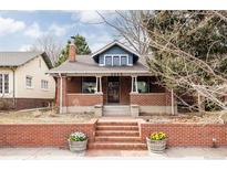Charming brick home featuring a brick fence, front steps, and a cozy blue-painted dormer at 2355 Forest St, Denver, CO 80207
