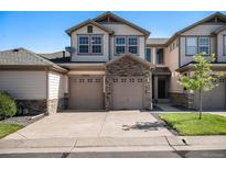 Charming two-story townhome featuring a stone facade and two-car garage at 23235 York Ave, Parker, CO 80138