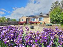 Charming home featuring solar panels, complemented by vibrant purple flowers, and beautiful landscaping at 3493 S Eudora St, Denver, CO 80222