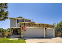 Charming home featuring a stone-accented, attached two-car garage and well-maintained lawn at 4276 S Tempe Ct, Aurora, CO 80018