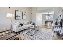 Bright living room with modern decor, stylish rug, and adjacent dining space at 4620 E 135Th Way, Thornton, CO 80241