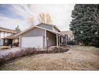 Charming gray home featuring a two-car garage, front yard and a well maintained lawn at 10375 E Weaver Cir, Englewood, CO 80111