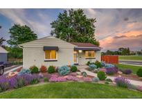 Charming brick home featuring professional landscaping with colorful flowers and mature trees at 488 S Leyden St, Denver, CO 80224