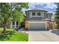 Charming two-story home featuring gray painted and brick accents, landscaped lawn and a spacious two-car garage at 10822 Eagle Crest Ct, Parker, CO 80138