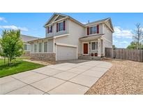 Charming two-story home with a well-maintained front yard, concrete driveway, and an attached garage at 13152 E 104Th Dr, Commerce City, CO 80022