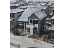 Charming two-story home features a modern design with blue and white exterior and snow-covered roof at 1732 Stable View Dr, Castle Pines, CO 80108