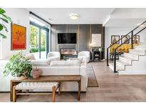 Open-concept living room with modern fireplace, comfortable seating, and hardwood floors at 4200 W 17Th Ave # 53, Denver, CO 80204
