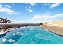 Stunning rooftop pool with mountain views and lounge area on a sunny day at 410 Acoma St # 309, Denver, CO 80204