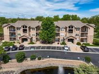 Beautiful condo building featuring well-maintained landscaping, pond, and ample parking for residents and guests at 10787 Twenty Mile Rd # 205, Parker, CO 80134