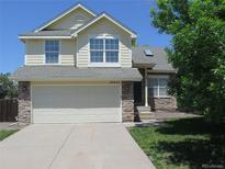Charming two-story home featuring a well-manicured lawn, stone accents, and an attached two-car garage at 19421 E Evans Dr, Aurora, CO 80013