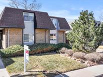 Charming townhome with brick facade, lush landscaping, and a 'For Sale' sign on a sunny day at 2323 S Jamaica St, Aurora, CO 80014