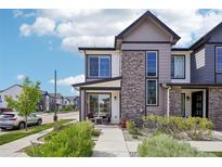 Beautiful two-story home featuring stone accents, a covered porch, and professional landscaping at 19733 W 93Rd Ln # A, Arvada, CO 80007