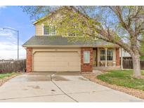 Charming two-story home features a brick facade, two-car garage, and inviting front porch with seating area at 1261 E 135Th Pl, Thornton, CO 80241