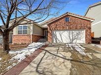 Brick ranch home with attached garage and landscaped yard at 445 Tumbleweed Dr, Brighton, CO 80601