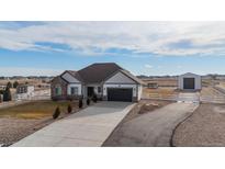 Charming single-story home featuring stone accents, a long driveway, and a detached garage at 11200 E 166Th Ave, Brighton, CO 80602