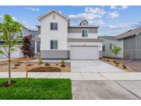 Charming two-story home with a two-car garage, landscaped front yard, and attractive white and gray exterior at 1416 Orchard St, Brighton, CO 80601
