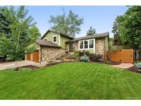 Charming two-story home featuring a brick facade, lush lawn, and inviting landscape at 6248 E Mineral Pl, Centennial, CO 80112