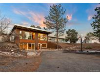 Beautiful two-story home with a large front yard and mountain views at sunset at 428 N Perry Park Rd, Sedalia, CO 80135