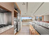 Modern kitchen featuring stainless steel appliances and a large window with scenic views at 428 N Perry Park Rd, Sedalia, CO 80135