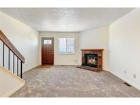 Cozy living room featuring a brick fireplace and neutral carpeting at 17102 E Baltic Dr # F, Aurora, CO 80013