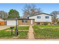Charming two-story home featuring a well-maintained lawn, brick accents, and inviting curb appeal at 1430 Lashley St, Longmont, CO 80504