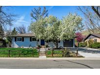 Charming home featuring blooming tree, well-kept lawn, and inviting entrance, with attached garage and driveway at 2435 Creighton Dr, Golden, CO 80401