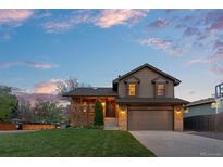 Charming two-story home featuring a well-manicured lawn, brick accents, and a two-car garage at 12017 W Cross Dr, Littleton, CO 80127
