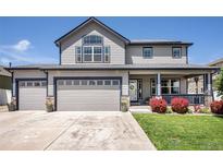 Charming two-story home with a three-car garage, covered porch and manicured lawn at 5475 Shoshone Dr, Longmont, CO 80504