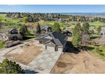 Stunning two-story home with a three-car garage and professionally designed concrete driveway and lush green landscaping at 7778 Windwood Way, Parker, CO 80134