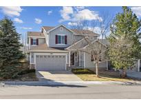 Charming two-story home with gray siding, burgundy shutters, and a well-manicured front yard in a friendly neighborhood at 10781 Huntwick St, Highlands Ranch, CO 80130