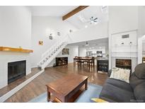 Open-concept living room features a fireplace, hardwood floors, and plenty of natural light at 23551 Genesee Village Rd # H, Golden, CO 80401